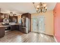 Modern kitchen boasts stainless steel appliances, dark cabinetry, and an adjacent dining area with French doors at 3659 W Union Ave, Denver, CO 80236