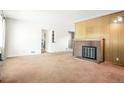 Spacious living room with pink carpet, white walls, a brick fireplace and a doorway leading to other rooms at 409 Lookout View Dr, Golden, CO 80401