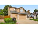 Two-story home showcasing a large two-car garage, neutral siding, and manicured lawn at 12013 W 56Th Cir, Arvada, CO 80002