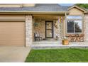 Inviting front porch with stone accents, seating, and charming decor at 12013 W 56Th Cir, Arvada, CO 80002