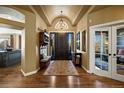 Welcoming foyer boasts hardwood floors, a vaulted ceiling, and a decorative chandelier, setting an elegant tone at 724 Evening Star Dr, Castle Rock, CO 80108