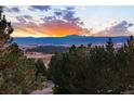 Picturesque mountain views at sunset highlight the natural beauty of this expansive property at 724 Evening Star Dr, Castle Rock, CO 80108