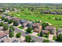 Beautiful aerial view of the neighborhood with a golf course, mature trees, and well-maintained homes at 12000 Pine Top St, Parker, CO 80138