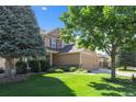 Charming two-story home features a well-manicured lawn, mature trees and a three car garage at 12000 Pine Top St, Parker, CO 80138