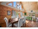 Cozy dining room featuring log walls, vaulted ceiling, and modern decor at 9868 Overlook Rd, Sedalia, CO 80135