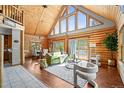 Inviting living room with vaulted ceilings, large windows, and cozy fireplace at 9868 Overlook Rd, Sedalia, CO 80135