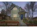 Charming two-story home featuring a cozy front porch and landscaped garden at twilight at 3225 Olive St, Denver, CO 80207