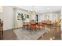 Bright dining room featuring hardwood floors, designer light fixture, and a large window with view at 7092 E Mexico Ave, Denver, CO 80224