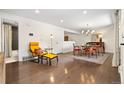 Open-concept living area featuring hardwood floors, modern furnishings, and access to the bathroom at 7092 E Mexico Ave, Denver, CO 80224