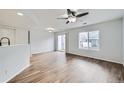 Open-concept living room with wood floors, sliding glass doors, and a large window at 19046 E 57Th Pl # B, Denver, CO 80249