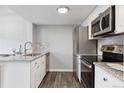 Bright kitchen featuring stainless steel appliances, white cabinets, and wood-look flooring at 3100 S Federal Blvd # 331, Denver, CO 80236