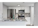 Modern kitchen featuring stainless steel appliances, granite countertops, and white cabinetry at 3100 S Federal Blvd # 331, Denver, CO 80236
