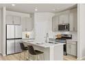 Modern kitchen featuring stainless steel appliances, island with seating, and ample cabinet space at 762 N Rome St, Aurora, CO 80018