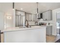 Modern kitchen with gray cabinets, stainless steel appliances, and quartz countertops at 5565 W Arizona Ave, Lakewood, CO 80232