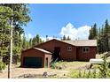 Charming mountain home with a detached garage, propane tank, and surrounded by lush greenery at 250 Upper Forest Rd, Idaho Springs, CO 80452