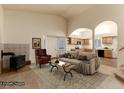 Inviting living room with high ceilings, fireplace, archways, and a view into the kitchen at 250 Upper Forest Rd, Idaho Springs, CO 80452