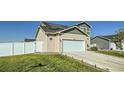 Two-story home with a two-car garage, solar panels, and a privacy fence surrounding the backyard at 529 Beckwourth, Fort Lupton, CO 80621