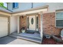 Close-up of the front entrance featuring a welcoming door, brick accents, and decorative plants at 4571 S Memphis St, Aurora, CO 80015