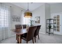 Dining room with hardwood table, leather chairs, modern chandelier, and natural light; perfect for Gathering gatherings at 6283 Kilmer Loop # 201, Golden, CO 80403