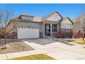 A beautiful home featuring stone details, an attached two-car garage, and a well-maintained lawn at 23600 E Swallow Cir, Aurora, CO 80016