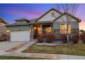 Exterior daytime shot of a charming home with stone accents and an attached two-car garage at 23600 E Swallow Cir, Aurora, CO 80016