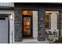 Inviting front porch with stone columns, seating, and a view into the cozy interior at 14845 Haley Ave, Parker, CO 80134