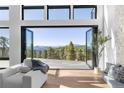 Living room featuring mountain views and deck access through retractable doors, with a modern chair at 13415 S Resort Dr, Conifer, CO 80433