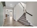 Inviting entryway with hardwood floors, staircase, and a view of the open-concept living area at 247 N Coolidge Way, Aurora, CO 80018