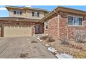 Charming two-story home features a brick and siding exterior, attached garage, and a well-maintained front yard at 247 N Coolidge Way, Aurora, CO 80018