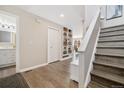 Bright entryway with wood floors, stairs, coat closet, and views to the living room and main floor bathroom at 2263 E 129Th Ave, Thornton, CO 80241