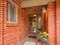 Covered front entry with brick facade, complemented by decorative potted plants at 3481 S Race St, Englewood, CO 80113