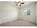 Cozy bedroom features carpet, a ceiling fan, and a bright window at 1868 Homestead Dr, Fort Lupton, CO 80621