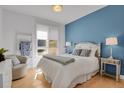 Cozy bedroom featuring a mirrored bedframe, stylish bedside tables, and a calming blue accent wall at 2500 E Cherry Creek South Dr # 116, Denver, CO 80209