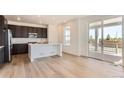 Modern kitchen featuring dark cabinets, white countertops, stainless steel appliances, and an eat in island at 647 Nightsky St, Erie, CO 80516