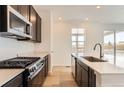 Kitchen with white countertops, stainless steel appliances and a gas range at 647 Nightsky St, Erie, CO 80516