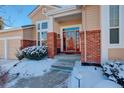 Inviting front entrance with red door and brick accents at 3016 Greensborough Dr, Highlands Ranch, CO 80129