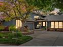 Charming single-Gathering home at twilight, featuring manicured landscaping, and exterior uplighting at 7055 E Heritage S Pl, Centennial, CO 80111