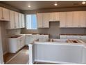 Spacious kitchen featuring white cabinets, a large window, and an unfinished island at 2261 Peregrine Dr, Brighton, CO 80601