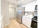 Modern kitchen featuring stainless steel appliances, white cabinets, and light-colored flooring at 14006 E Stanford Cir # K08, Aurora, CO 80015