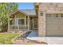 Attractive exterior with a well-kept lawn, brick accents, and a cozy porch at 10762 W 54Th Pl, Arvada, CO 80002