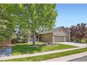 Charming home featuring a three-car garage, brick facade, front porch, and a well-maintained lawn at 10762 W 54Th Pl, Arvada, CO 80002