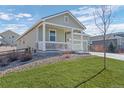 Single-Gathering home showcasing a two-car garage, a covered porch, and manicured lawn at 42338 Forest Oaks Dr, Elizabeth, CO 80107