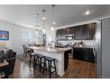 Modern kitchen features a granite island, stainless steel appliances, and dark cabinetry with pendant lighting at 4680 Copeland Loop # 204, Highlands Ranch, CO 80126