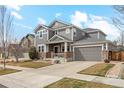 Charming two-story home showcases stone accents, neutral siding, manicured lawn, and an attached two-car garage at 15440 Carob Cir, Parker, CO 80134