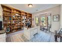 Home office with built-in bookshelves and a large desk at 5100 S Monaco St, Greenwood Village, CO 80111