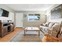 Cozy living room featuring hardwood floors, a comfortable sofa, and a bright window at 2011 S Vallejo St, Denver, CO 80223