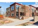 Attractive townhome with brick facade, second story balcony, and walkway with landscaped features at 1820 Mary Ln # 1, Boulder, CO 80304
