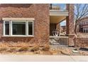 Close up of a brick wall with a window and a covered patio with a hanging hammock chair at 1820 Mary Ln # 1, Boulder, CO 80304