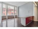 Modern kitchen with red cabinets, white marble countertop, and large windows with brick building view at 720 16Th St # 306, Denver, CO 80202