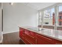 Modern kitchen with marble island and stylish red cabinetry with great natural light from the large windows at 720 16Th St # 306, Denver, CO 80202